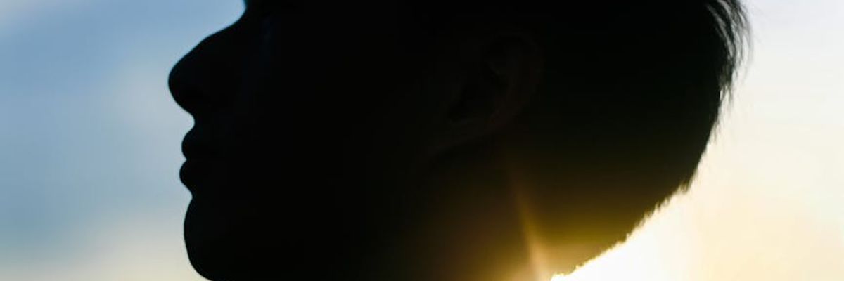 Person meditating with glowing visual points around head.